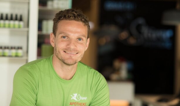 Bild des Ansprechpartners Mag. Knut Palten mit einem grünen T-Shirt in der Apotheke